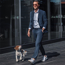 man in dress pants walking dog