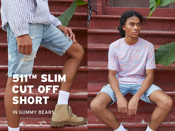 male model in jean shorts sitting on a set of stairs outdoors